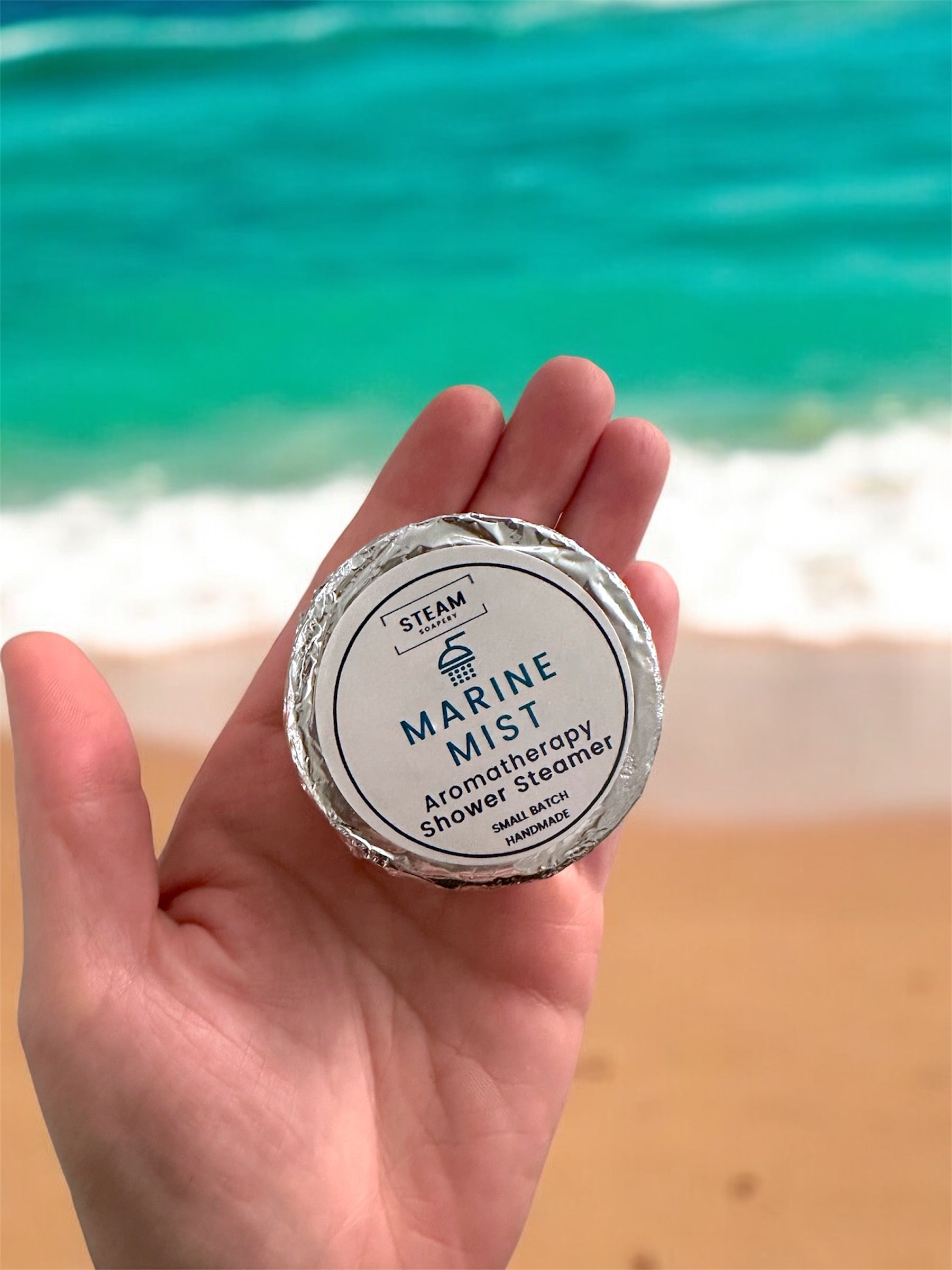 Marine Mist Shower Steamer on Hand above Ocean
